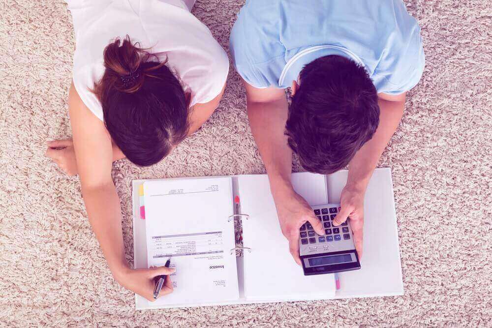 High angle view of couple calculating budget together.