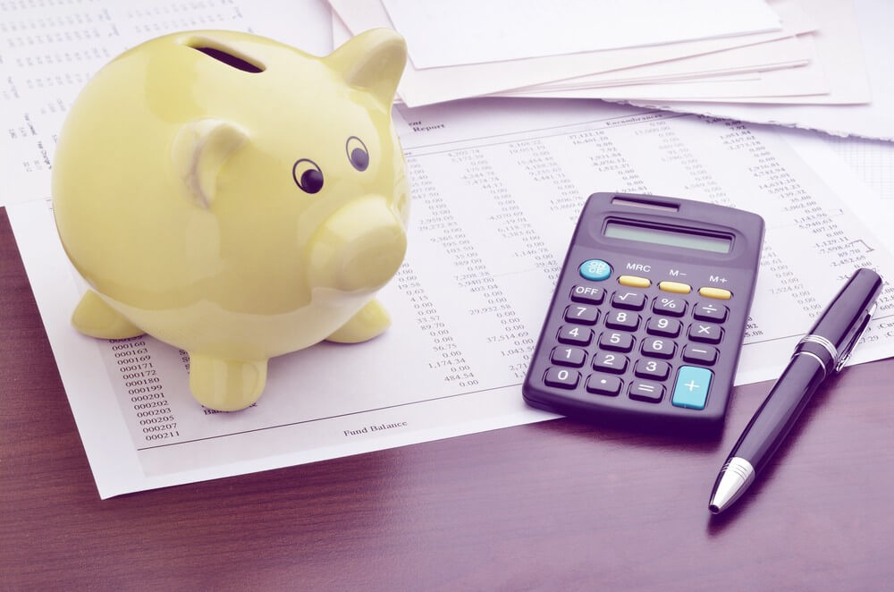 Piggy bank with calculator and business reports.