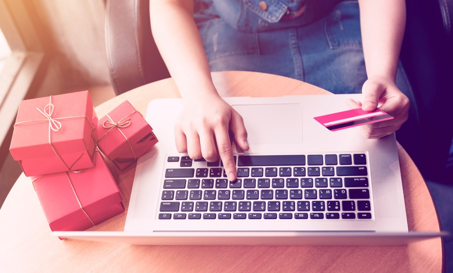 Top view of woman hand holding credit card and doing shopping online.