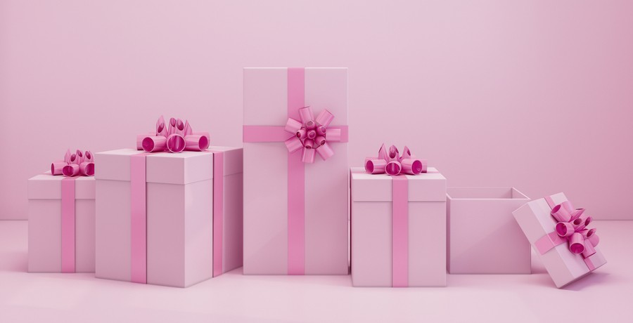 Pink gift box with pink ribbon bow on pink background.