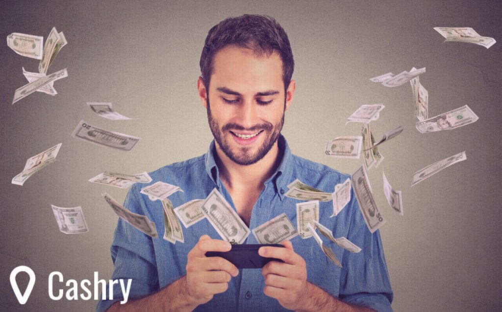 Happy young man using smartphone with dollar bills flying away.